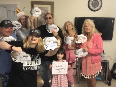 Seven family members smile for a photo while holding up World Narcolepsy Day signs.