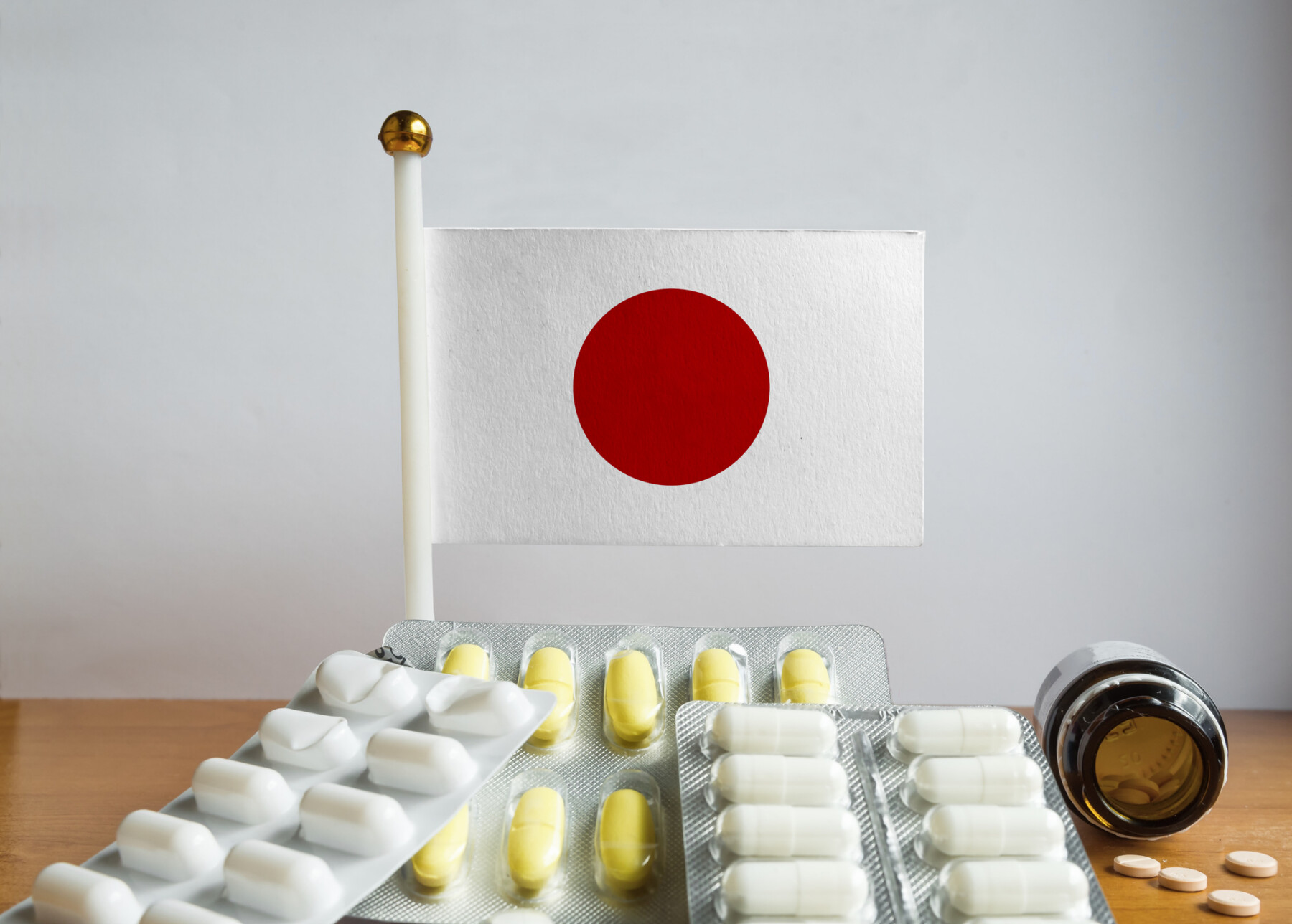 Image of flag of Japan with pills and capsules.