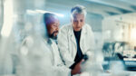Two researchers in a lab confer about data.