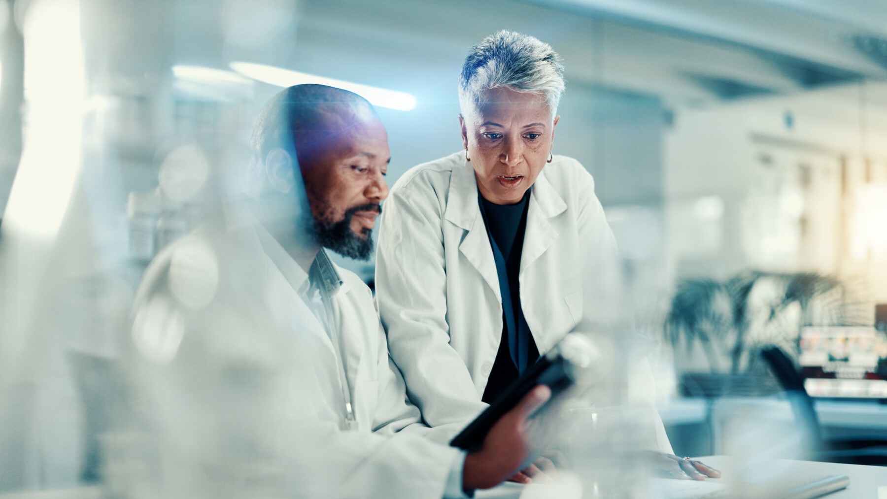 Two researchers in a lab confer about data.