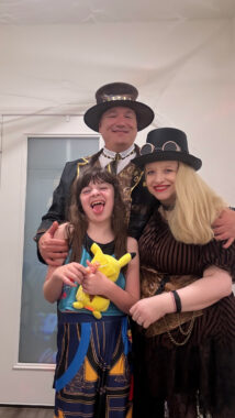 A mother, father, and their daughter pose for a family photo while dressed in their Halloween costumes, which seem to be steampunk-inspired.