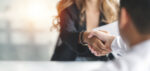 A woman and a man shake hands.