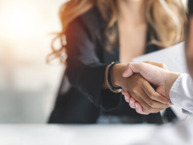 A woman and a man shake hands.